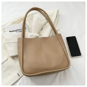 Detail of minimalist cream PU tote bag with U-shaped stitching on white texture