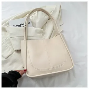 Close-up of minimalist cream PU leather tote bag with elegant U-shaped stitching detail