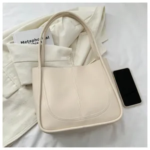 Top-down view of a beige minimalist tote bag with smartphone and book on fabric