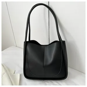 Detail view of large black PU leather tote bag with U-shaped stitching and long straps