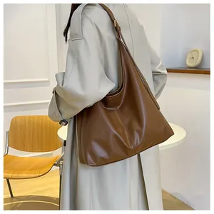 Sac hobo vintage marron foncé avec texture souple et coutures verticales sur l'épaule