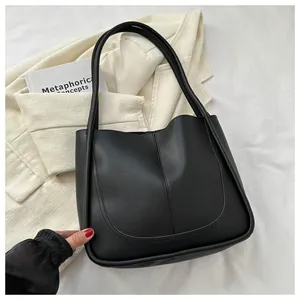 Detail view of high-quality black PU leather tote bag with elegant curved stitching