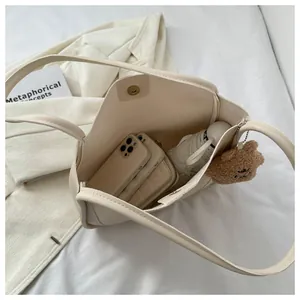 Top view of cream white tote bag interior capacity showing phone, umbrella and accessories