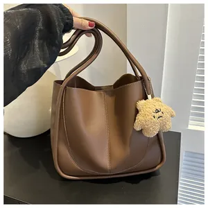 Detail of dark brown matte PU leather tote bag with soft plush star shaped charm
