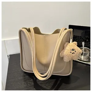 Detail of beige PU leather tote bag with star charm and minimalist office desktop items