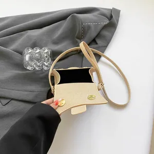 Mini beige square crossbody bag with textured finish, gold magnetic snaps and shoulder strap