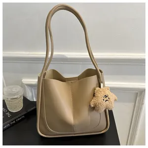 Detail of khaki PU leather tote bag with stitch pattern and plush star keychain