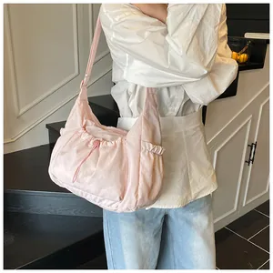 Detailopname van de lichtroze nylon puffertas met zijvakken en trekkoorddetails