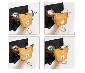 Four-color straw bucket bags featuring vibrant woven handles and cartoon fabric labels