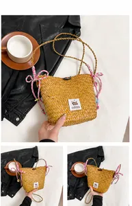 Detail of pink straw bucket bag with Capybara patch and woven bow decorations