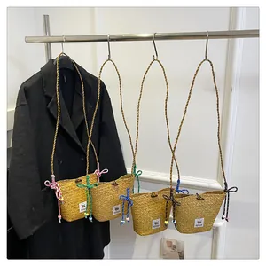 Detail of four woven straw bucket bags with colorful beaded straps and logo patch