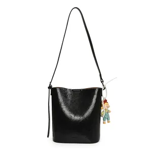 Minimalist black pleated bucket bag with long strap and cute pearl pendant