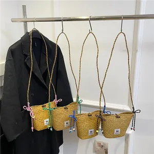 Handmade woven straw bucket bag with colorful rope straps and cute butterfly accents