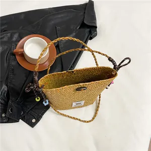 Minimalist straw woven handbag with cartoon patch and floral charm for 2025 fashion