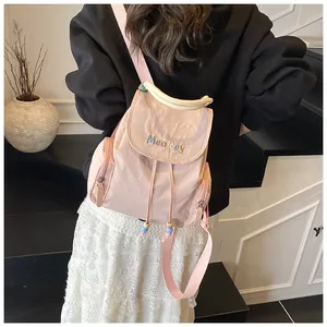 Détail d'un sac à dos en nylon rose avec broderie MeaRey et cordon de serrage