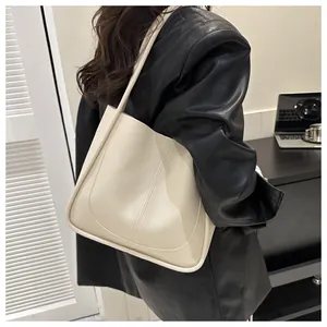 Close-up of cream PU leather tote bag with vertical stitching and smooth texture