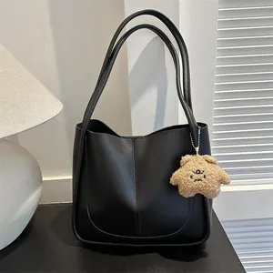Minimalist black matte PU leather tote bag with U-shaped stitching and bear charm