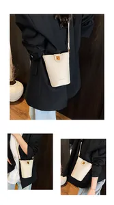 Detalle del bolso tipo cubo de cuero crema con cierre dorado y textura fina