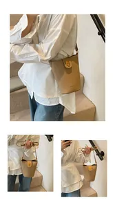 Detalle de bolso tipo cubo beige en cuero con textura de lichi y cierre dorado