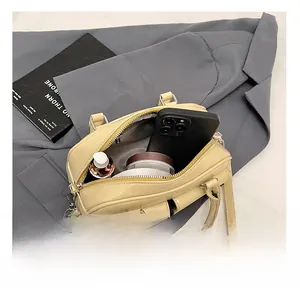Detail showing the internal capacity of the pale yellow Boston bag with daily essentials