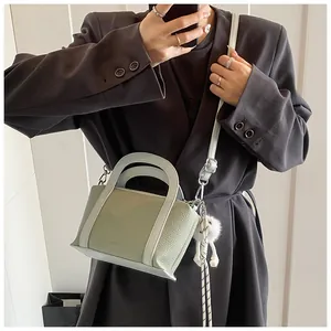 Secchiello motivo litchi verde e crema, abbinato a un blazer marrone oversize
