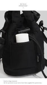 Detail of black nylon bucket bag showing mesh side pocket with water bottle storage