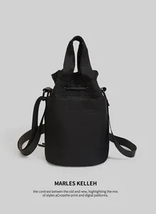 Detail of black drawstring bucket bag with mesh panel and adjustable shoulder strap