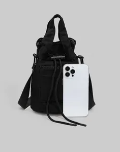 Mini nylon drawstring bucket bag with mesh pocket shown next to a smartphone for size scale