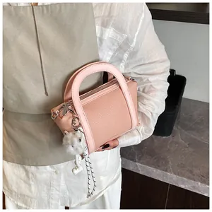 Borsa a secchiello rosa trama litchi con ciondolo a gatto in peluche, dettaglio a mano