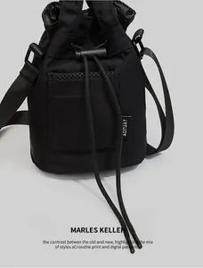 Detail of black drawstring bucket bag with mesh pocket and adjustable shoulder strap