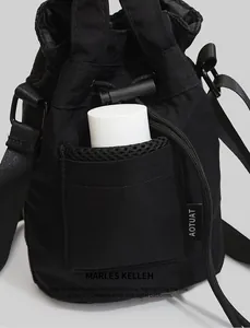 Detail of black drawstring bucket bag showing the mesh front pocket for water bottles