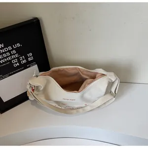 Détail du sac beige avec imprimé chat de dessin animé et fermeture à glissière lisse