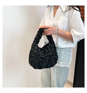 Detailed shot of black pleated handbag texture with elegant ruffles and slouchy design