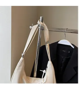 Détail de la bandoulière en cuir crème lisse et texture du grand sac demi-lune