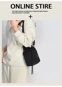 Detail view of black drawstring bucket bag with adjustable strap and front pocket