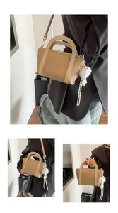 Dettaglio borsa a secchiello beige con trama litchi e ciondolo in peluche