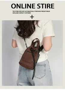 Rear view of model wearing a brown canvas bucket bag with adjustable strap for travel