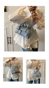 Detail of light blue glossy Boston bag with pearl bow charm and twin front pockets