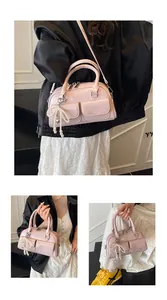Detailed views of pink Boston bag with dual handles and pearl bow pendant decoration