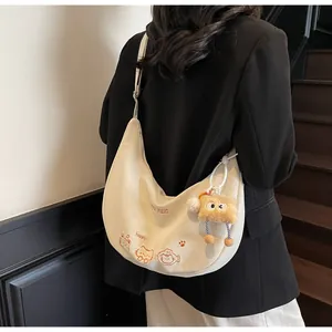 Détail de la broderie chat et du charm toast sur le sac en toile beige de style