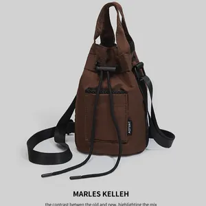 Dark brown drawstring bucket bag with mesh pocket and shoulder strap for outdoor sports