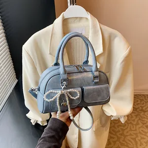 Light blue Boston bag with retro PU leather and pearl bow charm shown in hand