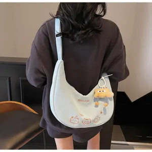 Détail de la broderie chat et du pendentif peluche sur le sac hobo bleu clair