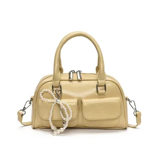 Minimalist beige Boston bag with faux leather texture and pearl charm detail