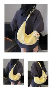 Détail du sac hobo jaune avec broderie de chat et pendentif ours en peluche doux