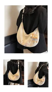 Détail du sac hobo en toile avec broderie chat et breloque peluche mignonne