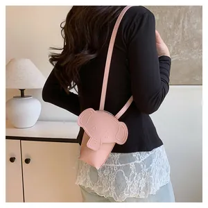 Rear view of pink elephant shaped crossbody bag showing size on model outfit