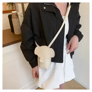 Close-up of cream PU leather elephant bag with 3D ears on a model in a cafe setting