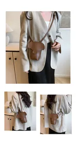 Detail view of mini elephant crossbody bag in brown faux leather with shoulder strap