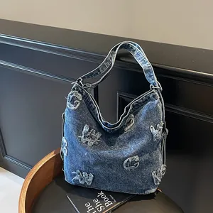 Large blue denim hobo bag with vintage distressed letter patches and soft shoulder strap